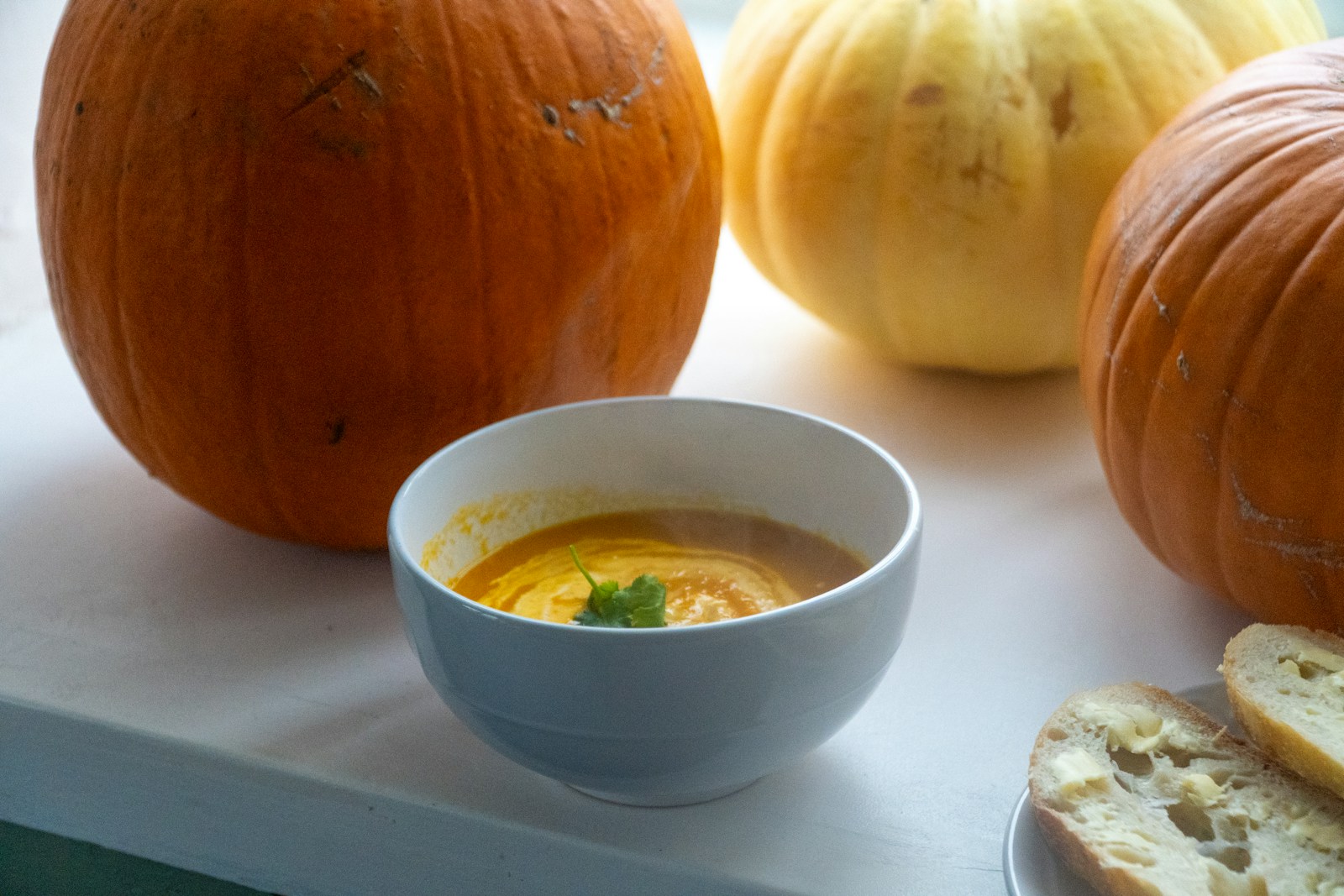 Cuenco de sopa de zapallo con pan y calabazas